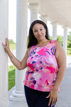 Load image into Gallery viewer, Woman wearing a pink floral sleeveless top standing on a white columned porch.
